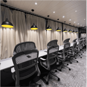 Modern coworking space in Vijay Nagar, Indore with ergonomic chairs, long desks, and stylish pendant lighting.